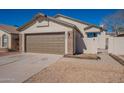 A house featuring a two-car garage, xeriscaping, and a light stucco exterior with stone accents at 8772 W Grovers W Ave, Peoria, AZ 85382