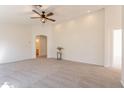 Spacious, light-filled living room with plush carpet, a ceiling fan, and neutral paint at 9705 E Butte St, Mesa, AZ 85207