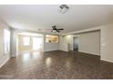 Bright, open-concept living room features tile floors, a ceiling fan, and plenty of natural light at 11609 W Corrine Dr, El Mirage, AZ 85335