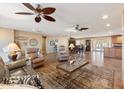 Spacious open-concept living room with tile floors, neutral colors and multiple ceiling fans at 12530 W Skylark Dr, Sun City West, AZ 85375