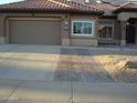 Home featuring desert landscaping, a paver driveway, and solar panels on the roof at 14432 W Robertson Dr, Sun City West, AZ 85375