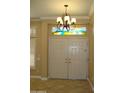 Beautiful foyer featuring a decorative light fixture and double doors at 14432 W Robertson Dr, Sun City West, AZ 85375