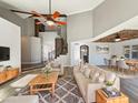 Bright living room featuring soaring ceilings, a modern ceiling fan, and an open floor plan to the dining area at 14645 S 25Th Pl, Phoenix, AZ 85048