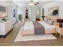 Bright main bedroom showcasing neutral tones, soft carpet, ceiling fan, and ample natural light at 16370 W Rimrock St, Surprise, AZ 85388