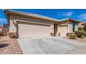 Charming home featuring a three-car garage, desert landscaping, and a stone-accented facade at 22754 W Moonlight Path, Buckeye, AZ 85326