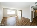 Bright living room with hardwood floors, a large window, and a view of the adjacent room at 2643 E Virginia Ave, Phoenix, AZ 85008