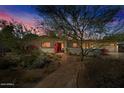 Charming single-story home with desert landscaping, a stone walkway, and a vibrant red front door at 318 E Concorda Dr, Tempe, AZ 85282