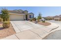 View of a single-Gathering home with a two-car garage and desert landscaping at 3973 N 310Th Ln, Buckeye, AZ 85396