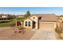 Inviting single-story home with lush green lawn, desert landscaping, tile roof, and an attached two-car garage at 41124 W Rio Bravo Dr, Maricopa, AZ 85138