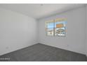 Bedroom with gray carpet and natural light coming through a window with a view of the neighborhood at 4145 W Eli Dr, San Tan Valley, AZ 85144