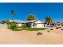 Charming single-story home with desert landscaping, mature trees, and an attached two-car garage at 4154 W Grovers Ave, Glendale, AZ 85308