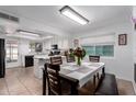 Bright kitchen with white cabinets and countertops, a dining table set, and ample natural light at 4154 W Grovers Ave, Glendale, AZ 85308