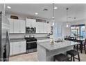 Modern kitchen featuring granite countertops, stainless steel appliances, and a breakfast bar with seating at 42195 W Lavender Dr, Maricopa, AZ 85138