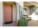 Inviting front porch with seating area, a decorative cactus, and brick pavers at 42920 W Kingfisher Dr, Maricopa, AZ 85138