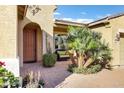 Inviting front porch with seating area, a decorative palm tree, and brick pavers at 42920 W Kingfisher Dr, Maricopa, AZ 85138