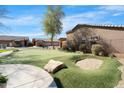 Private putting green with a sand trap, perfect for golf enthusiasts to practice their short game at 4528 W Valencia Dr, Laveen, AZ 85339