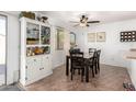 Bright dining room featuring a modern ceiling fan, tile flooring and a built in cabinet at 468 E Wolf Hollow Dr, Casa Grande, AZ 85122