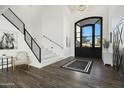 Welcoming entryway featuring high ceilings, modern light fixture, wood-look tile and a stylish staircase at 5601 E Caballo Dr, Paradise Valley, AZ 85253