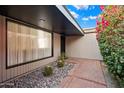 Inviting front entrance with decorative stones, cacti, a brick walkway, and a large window at 7334 N 7Th Ave, Phoenix, AZ 85021