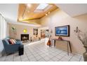 Open-concept living room with high ceilings, skylight, fireplace, tile floors, and modern decor at 7334 N 7Th Ave, Phoenix, AZ 85021