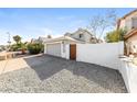 View of the home's garage with a wooden entry gate and concrete driveway at 7559 W Turquoise Ave, Peoria, AZ 85345