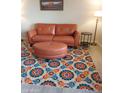 Cozy living room showcasing a brown couch and a colorful, patterned rug at 8649 E Royal Palm Rd # 213, Scottsdale, AZ 85258