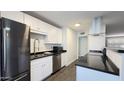 Modern kitchen featuring stainless steel appliances and sleek dark countertops at 10562 W Campana Dr, Sun City, AZ 85351
