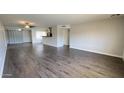 Open-concept living room featuring wood-look floors, neutral walls, and a partial kitchen view with stainless hood at 10562 W Campana Dr, Sun City, AZ 85351