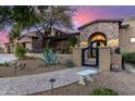 Stunning stone accented home featuring a gated courtyard, desert landscaping, and a brick walkway at 10638 E Hedgehog Pl, Scottsdale, AZ 85262