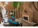 Charming outdoor patio with stone fireplace, wrought iron furniture, and decorative turtle wall hanging at 1152 W Horseshoe Ave, Gilbert, AZ 85233