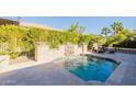 Private swimming pool with a charming rock water feature, creating a serene backyard oasis at 1488 E Sweet Citrus Dr, Queen Creek, AZ 85140