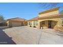 Rear view of the home showing the three car garage and desert landscaping at 2050 N 144Th Dr, Goodyear, AZ 85395