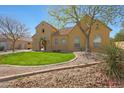 Charming home with lush green lawn, desert landscaping and a tile roof at 2050 N 144Th Dr, Goodyear, AZ 85395