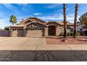 Charming single-story home featuring a three-car garage, desert landscaping, and a tile roof at 21041 N 61St Dr, Glendale, AZ 85308