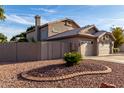 Rear view of a single-story home with desert landscaping and a fenced yard at 21041 N 61St Dr, Glendale, AZ 85308