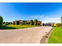Long, patterned brick driveway leads to a luxury home, with a large, black gated entrance at 21962 E Diana Way, Queen Creek, AZ 85142