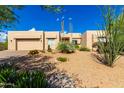 Front elevation of a modern desert home with drought-tolerant landscaping including cacti and succulents at 27467 N 75Th Way, Scottsdale, AZ 85266