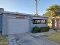View of the home's exterior with well maintained landscaping, driveway, and desert themed art at 276 Leisure World --, Mesa, AZ 85206
