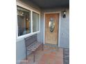 Inviting front door with decorative glass, adjacent bench, and covered porch area at 276 Leisure World --, Mesa, AZ 85206