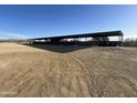 Expansive covered arena with a spacious dirt area, providing shelter for year-round horse training and riding activities at 35515 N 215Th Dr, Wittmann, AZ 85361