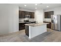 Contemporary kitchen featuring a large center island, dark wood cabinetry, and stainless appliances at 42855 W Vincent Dr, Maricopa, AZ 85138