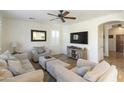 Comfortable living room featuring neutral furniture, a ceiling fan, and large-screen television at 44196 W Askew Dr, Maricopa, AZ 85138