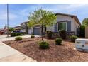 Attractive single-story home with desert landscaping, a two-car garage, and a well-manicured lawn at 4960 S Wade Dr, Gilbert, AZ 85298