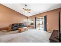 Comfortable living room featuring vaulted ceilings, neutral carpet, and a sliding glass door to the patio at 7515 W Jenan Dr, Peoria, AZ 85345