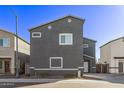 Two-story gray home with white trim on a sunny day at 1017 E Odeum Ln, Phoenix, AZ 85040