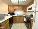 Functional kitchen with oak cabinets, white appliances, a skylight, and ample counter space at 10330 W Thunderbird Blvd # C128, Sun City, AZ 85351