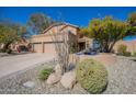 Charming home featuring a three-car garage, desert landscaping and a cozy front patio seating area at 10490 E Dreyfus E Ave, Scottsdale, AZ 85260