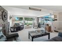 Bright living room featuring large windows with golf course views, comfortable seating and a stone fireplace feature at 11011 N Coggins Dr, Sun City, AZ 85351