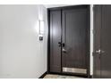 Stylish dark wood double front door with modern hardware, a security system, and a bright light fixture at 120 E Rio Salado Pkwy # 101, Tempe, AZ 85281
