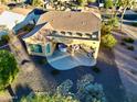 Aerial view of backyard with a covered patio, outdoor seating, and low-maintenance desert landscaping at 1822 N 164Th Dr # 58, Goodyear, AZ 85395